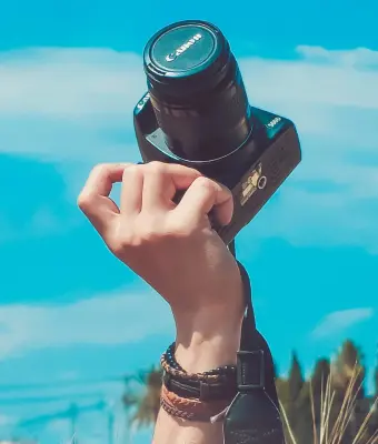 Zonsopkomst boven de bergen met een camera in de hand, klaar om de natuur vast te leggen.